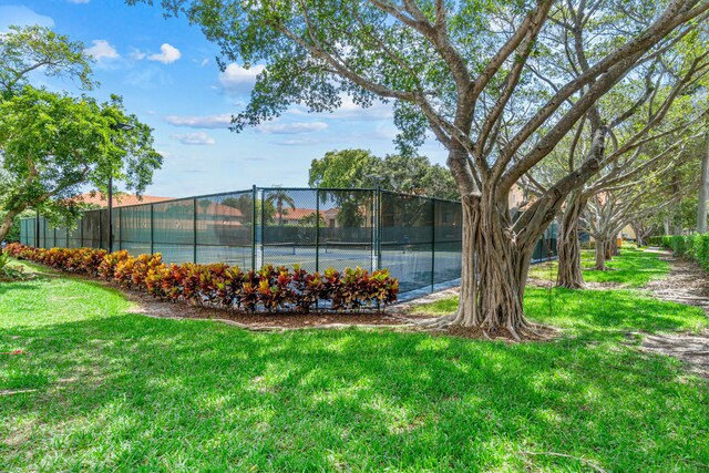 view of tennis court featuring a yard