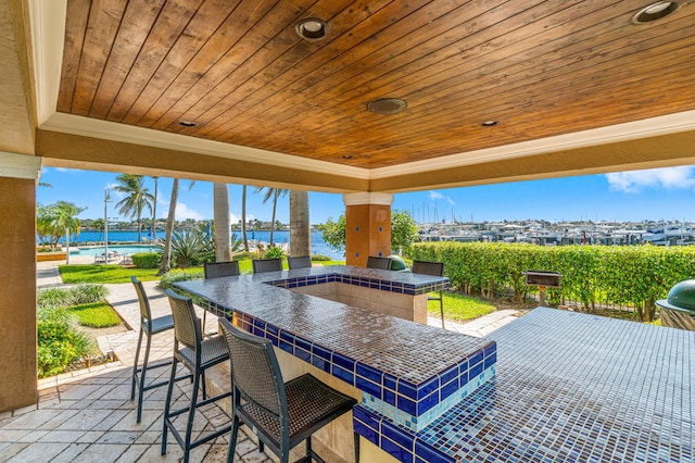 view of patio / terrace with an outdoor bar and a water view