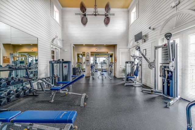 exercise room featuring a towering ceiling