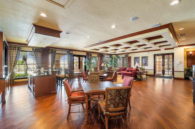 dining room featuring coffered ceiling, a textured ceiling, hardwood / wood-style flooring, and french doors