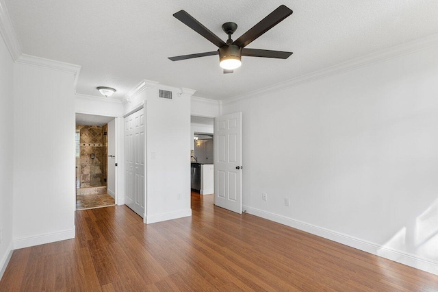 unfurnished bedroom featuring connected bathroom, ceiling fan, hardwood / wood-style flooring, and ornamental molding