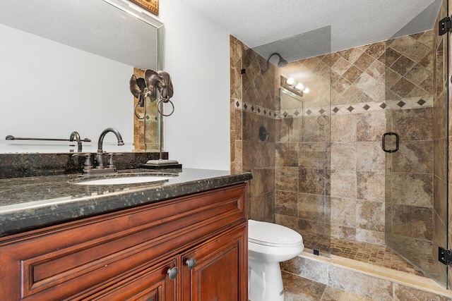 bathroom featuring walk in shower, vanity, a textured ceiling, and toilet