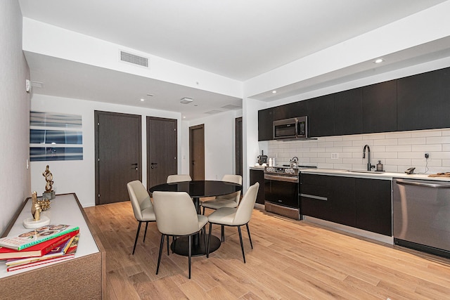 dining area featuring light wood-type flooring and sink