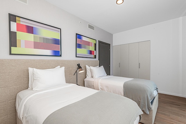 bedroom with hardwood / wood-style floors and a closet