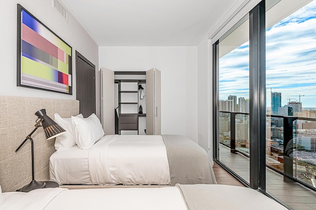 bedroom with access to exterior and wood-type flooring