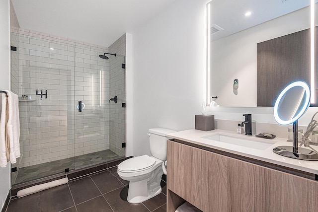 bathroom with tile patterned floors, walk in shower, vanity, and toilet