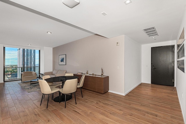 dining room featuring light hardwood / wood-style floors and a wall of windows