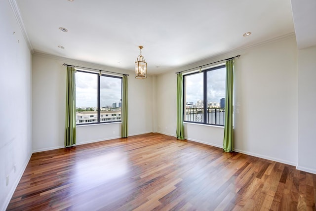 empty room featuring hardwood / wood-style flooring, plenty of natural light, and ornamental molding