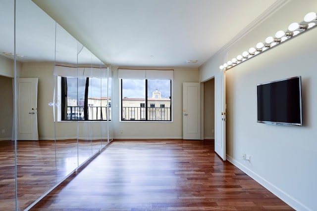 unfurnished room featuring ornamental molding and hardwood / wood-style floors