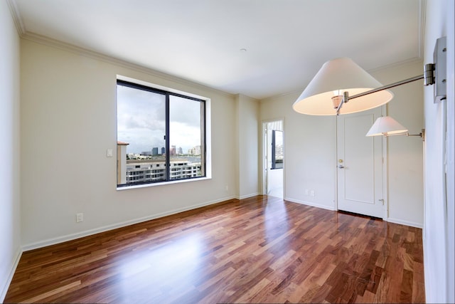 unfurnished room with dark hardwood / wood-style flooring and ornamental molding