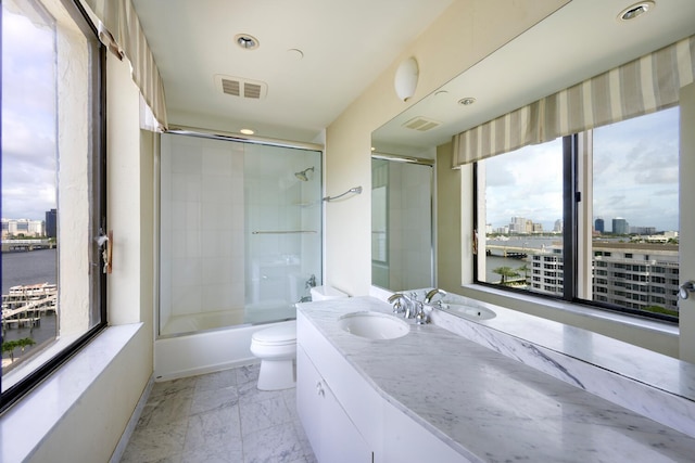 full bathroom with toilet, vanity, and shower / bath combination with glass door