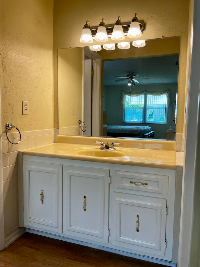 bathroom with wood-type flooring, vanity, and ceiling fan