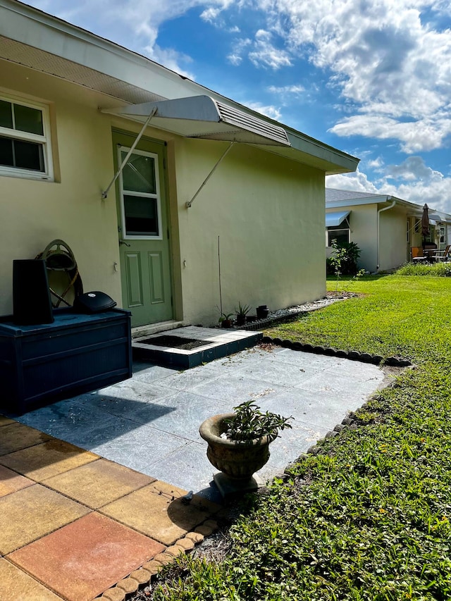 back of property featuring a yard and a patio area