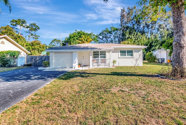 ranch-style house with stucco siding, a front lawn, aphalt driveway, fence, and a garage