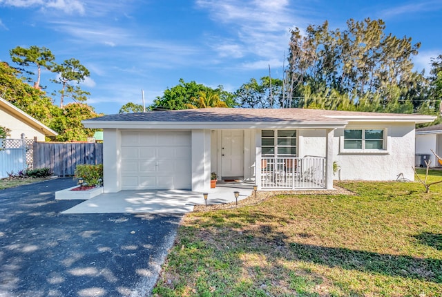 ranch-style house featuring stucco siding, aphalt driveway, fence, a front yard, and an attached garage