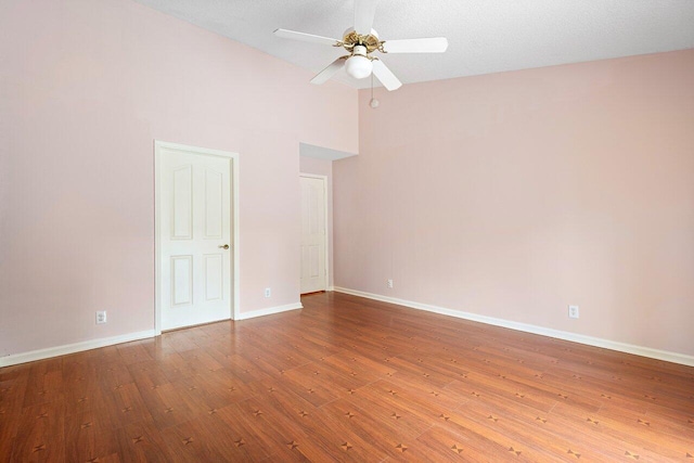 empty room featuring hardwood / wood-style floors, ceiling fan, and high vaulted ceiling