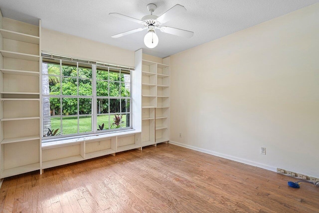 empty room with hardwood / wood-style flooring, a textured ceiling, and ceiling fan