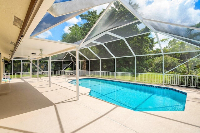 view of pool with a patio area and glass enclosure