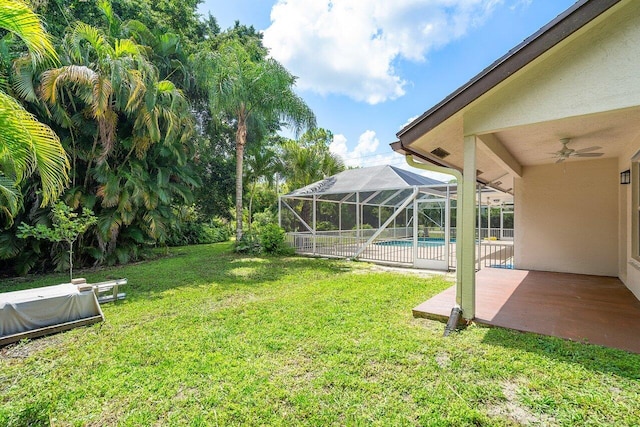 view of yard featuring ceiling fan, a patio area, and a lanai