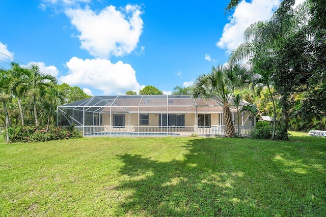 rear view of house featuring a lanai and a yard