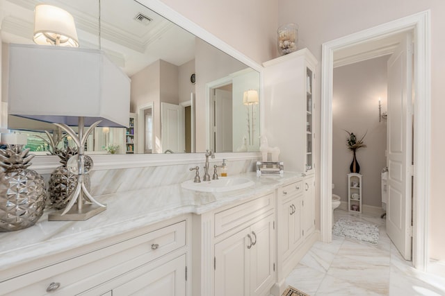 bathroom with crown molding, vanity, and toilet