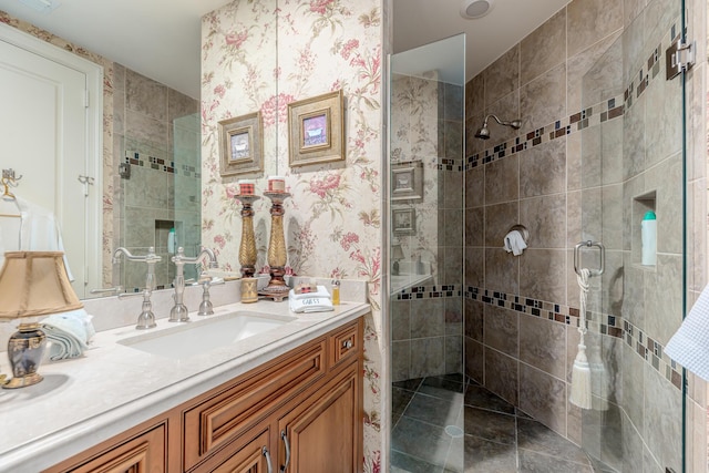 bathroom featuring tile patterned flooring, vanity, and tiled shower