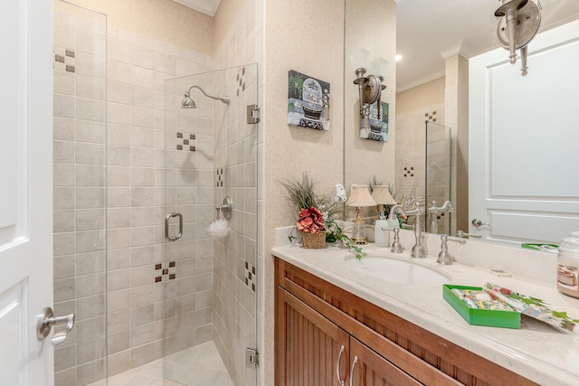 bathroom with vanity, a shower with shower door, and ornamental molding