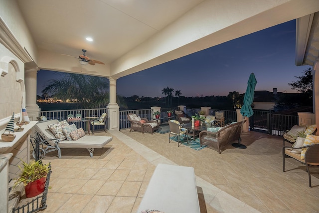 patio terrace at dusk with outdoor lounge area and ceiling fan