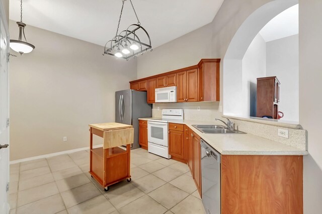 kitchen with sink, stainless steel appliances, light tile flooring, and pendant lighting