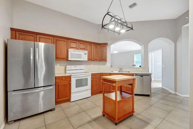 kitchen featuring a kitchen island, high vaulted ceiling, appliances with stainless steel finishes, sink, and light tile floors