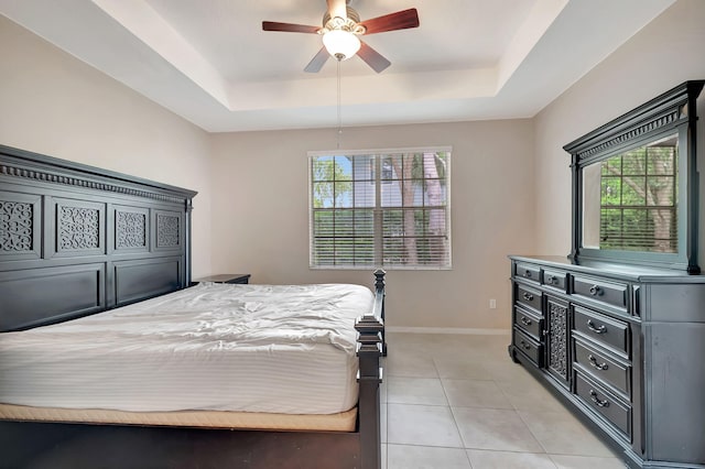 bedroom featuring tile floors, a raised ceiling, and multiple windows