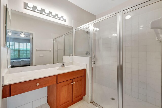 bathroom featuring walk in shower, tile flooring, ceiling fan, and vanity with extensive cabinet space