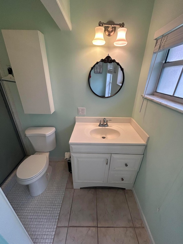 bathroom with tile flooring, toilet, and vanity