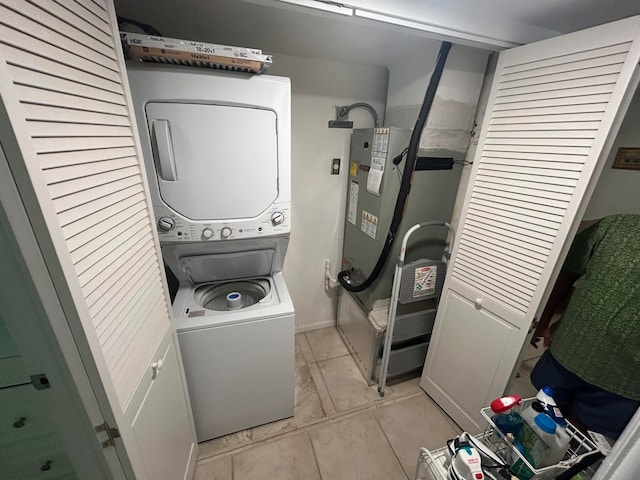 washroom featuring stacked washer and clothes dryer and light tile flooring