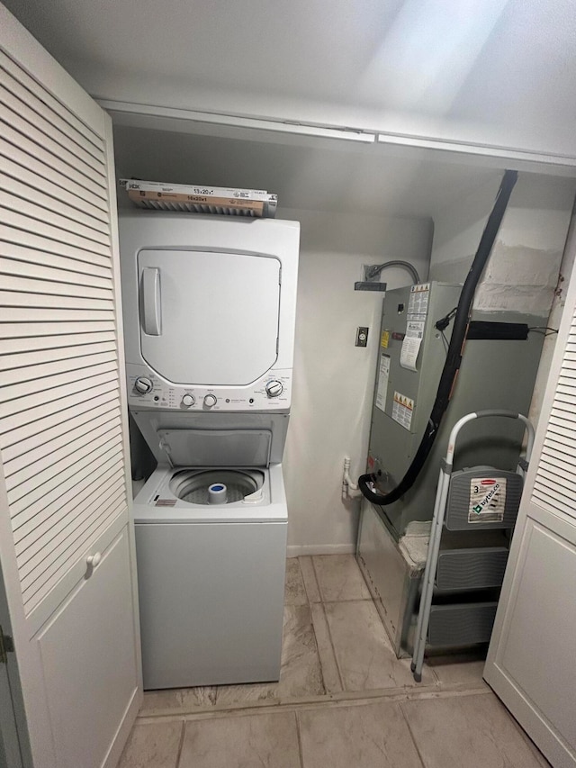 washroom with stacked washer and clothes dryer and light tile floors