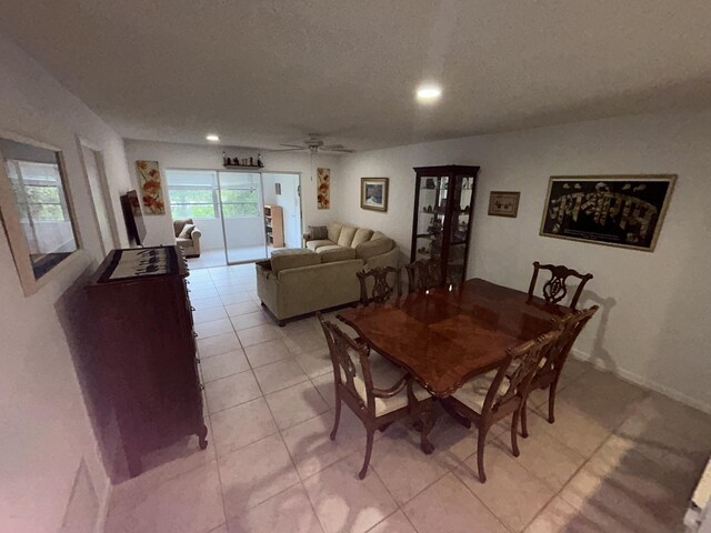 dining area with a textured ceiling, ceiling fan, and light tile floors