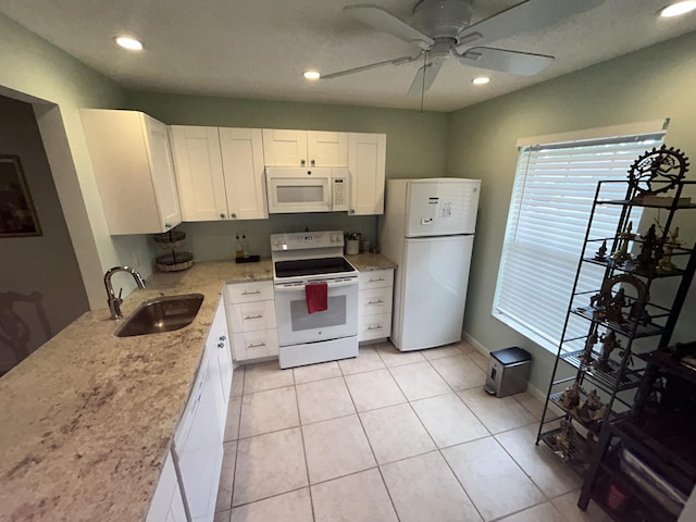 kitchen featuring a ceiling fan, a sink, white cabinetry, white appliances, and light stone countertops