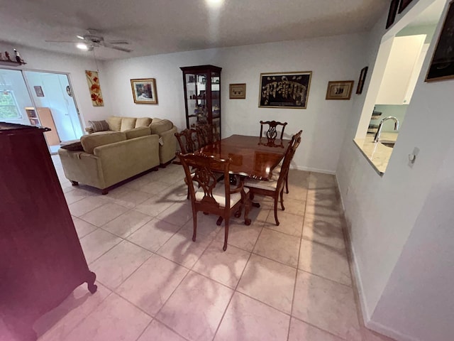 dining space featuring ceiling fan, light tile flooring, and sink