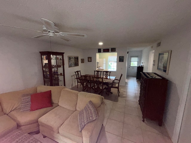 tiled living room featuring ceiling fan and a textured ceiling