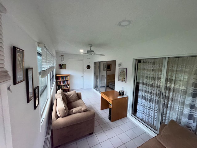 living room featuring a textured ceiling, ceiling fan, and light tile floors