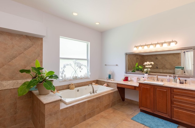 bathroom with tiled bath, vanity, and tile patterned flooring