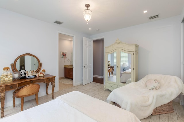 bedroom with light hardwood / wood-style floors, ensuite bathroom, and french doors