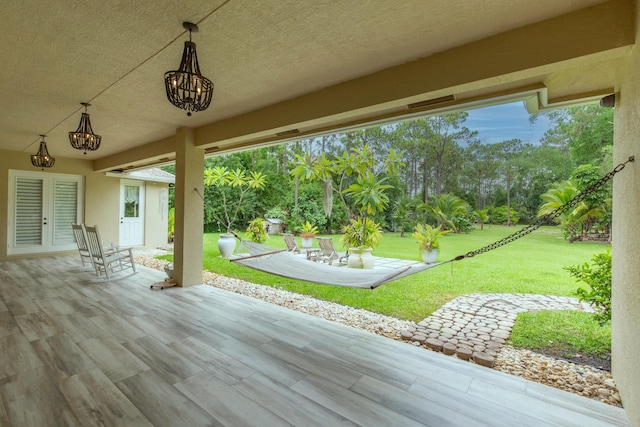 wooden deck featuring a yard, french doors, and a patio