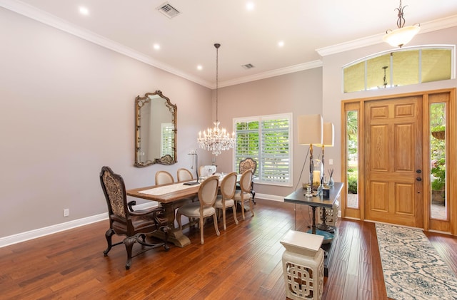 dining area with a high ceiling, dark hardwood / wood-style flooring, crown molding, and an inviting chandelier