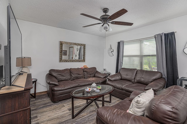 living room with a textured ceiling, ceiling fan, and dark hardwood / wood-style floors