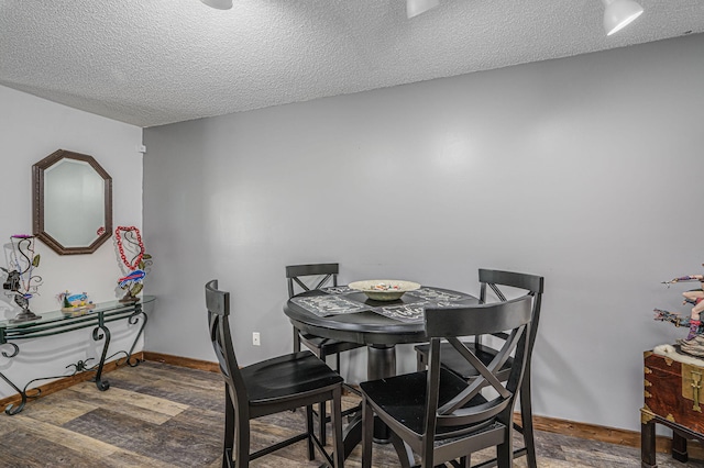 dining area with a textured ceiling and hardwood / wood-style floors