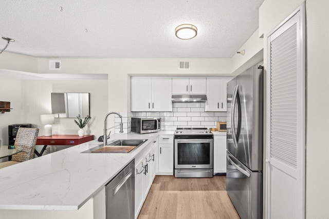 127 Yacht Club Way Unit 206, Hypoluxo, FL 33462 - kitchen featuring a sink, a peninsula, visible vents, and appliances with stainless steel finishes