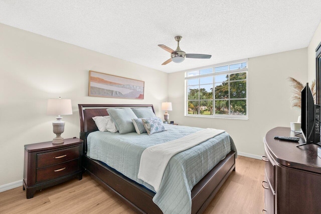 127 Yacht Club Way Unit 206, Hypoluxo, FL 33462 - bedroom with light wood-type flooring, baseboards, ceiling fan, and a textured ceiling
