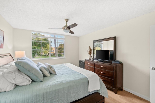 127 Yacht Club Way Unit 206, Hypoluxo, FL 33462 - bedroom with light wood finished floors, baseboards, a ceiling fan, and multiple windows