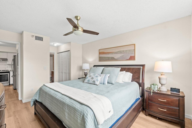 127 Yacht Club Way Unit 206, Hypoluxo, FL 33462 - bedroom with freestanding refrigerator, a closet, ceiling fan, visible vents, and light wood-style floors
